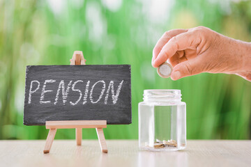 Hand of senior woman putting coin into jar on table outdoors. Concept of pension