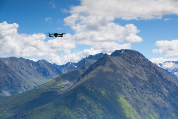 Quadrocopter out of the sky against the background of mountains.