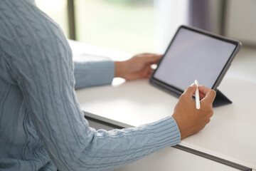 asian young student man entrepreneur working with tablet studying learning online at home. e-learning webinar meeting. social distance in covid pandemic
