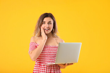 Naklejka premium Happy young woman with laptop on color background