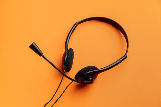 Headphones with microphone on color background