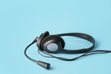 Headphones with microphone on color background