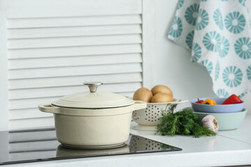 Cooking pot and vegetables on electric stove in kitchen