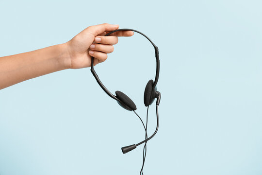 Female hand with headset on color background