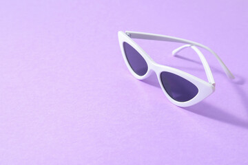 Stylish sunglasses on color background