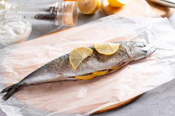 Raw mackerel with spices and lemon slices on the table