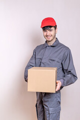 Delivery man in uniform delivering home delivery order, package in cardboard box.
