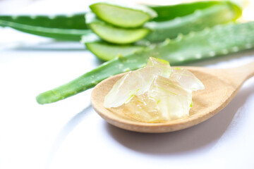 Close up aloe vera on wooden spoon on white background. Selective focus.