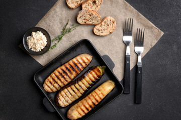 Frying pan with tasty grilled eggplant on dark background