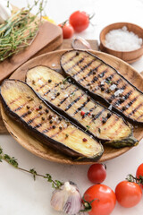 Plate with tasty grilled eggplant on table
