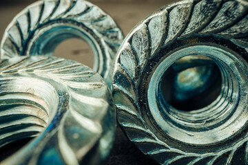 Macro shot of metal nuts on textured surface