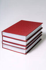 Stack of red hardcover books or reports on white background. Copy space.