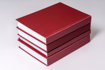 Stack of red hardcover books or reports on white background. Copy space.