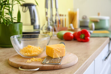 Tray with grater, bowl and cheese in kitchen