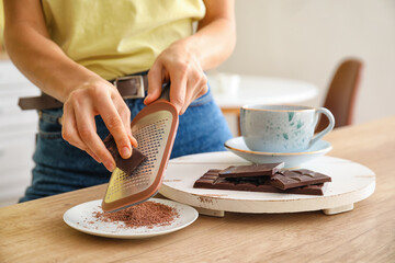 Woman grating chocolate in kitchen
