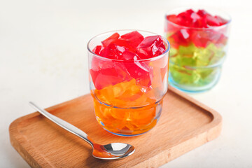 Glass with tasty jelly cubes on table