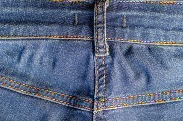The back of the blue jeans with yellow threads.