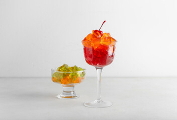 Glass bowls with tasty jelly cubes on white background
