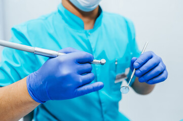 Hands of dentist with dental equipment.