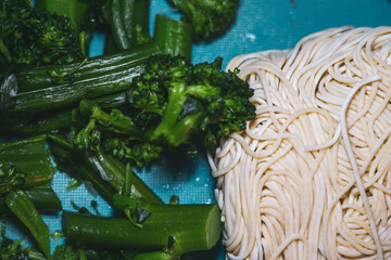 Broccoli and Ramen Noodles on Blue Background