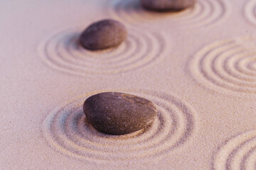 Zen garden stones on sand with ornament