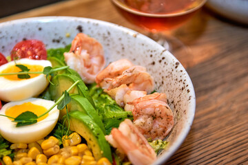 Delicious shrimp salad in restaurant on a wooden table. Tasty seafood with beer in cafe or pub menu.