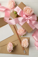 8 march concept with gift box and envelopes on white wooden background, space for text