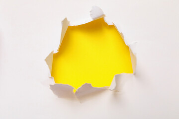 Hole in paper on yellow background, space for text