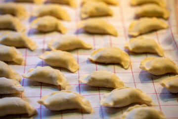 Dumplings are made by hand. Raw dumplings stuffed with meat in line in the home kitchen