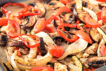 Oven vegetables like bell pepper, tomato, zucchini, mushroom, fennel and eggplant on a baking tray as full frame food background, selected focus, narrow depth of field