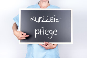 Altenpflegerin oder Krankenschwester mit einer Tafel Kurzzeitpflege