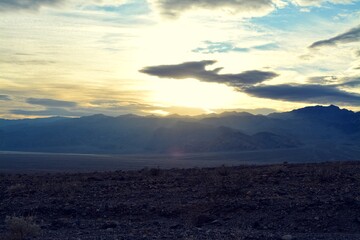 evening sky with the sun breaking through clouds with a view to the panamint range and the Death Valley Wash in the National Park