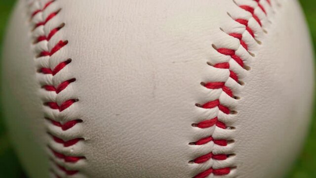 Close up of baseball ball on green background