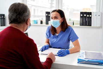 Female doctor talking with a senior patient in doctor's office