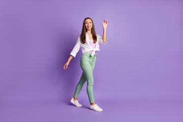 Full length photo of lady go waving hand wear footwear trousers white shirt isolated purple color background