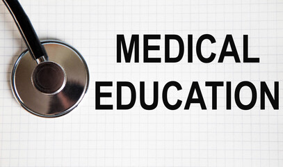 In the notebook is the text of Medical Education, next to the stethoscope.