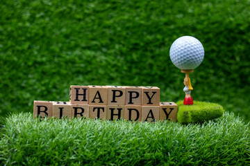 Golf ball with Happy Birthday word is on green grass