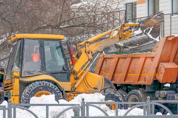 Frontloader removes snow from the sidewalk