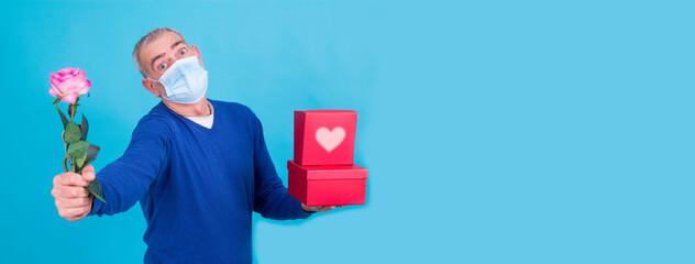 attractive  senior man with gift box and flower. birthday or valentines day concept