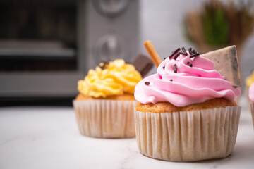 Delicious homemade cupcakes with Colorful cream and topping with candy and Chocolate Cookies. Homemade autumn holiday dessert