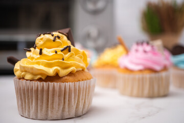 Delicious homemade cupcakes with Colorful cream and topping with candy and Chocolate Cookies. Homemade autumn holiday dessert