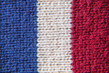 knitted material close-up with stripes of flowers blue white red