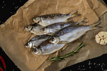 Smoked fish on paper. Dark background