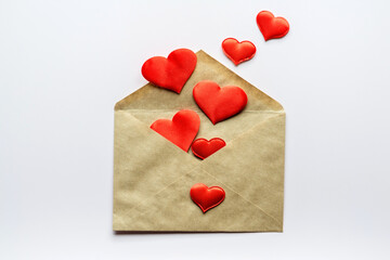Valentine's day background- decorative red hearts and kraft envelope. Love romantic concept. Flat lay, top view, copy space.