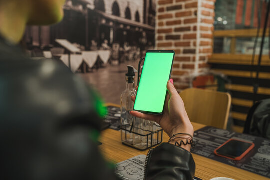 Using smartphone with green screen in coffee shop