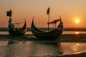 Landscape view at sunset of beautiful traditional wooden fishing boats known as moon boats on beach near Cox's Bazar in southern Bangladesh