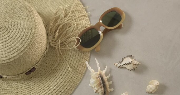Summertime, vacation, travel and tourism concept - female straw hat and sunglasses lie on beach sand. Travel summer accessories with  copy space, flat lay. Travel planning concept