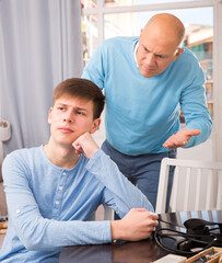 Portrait of angry father quarreling with his teenage son