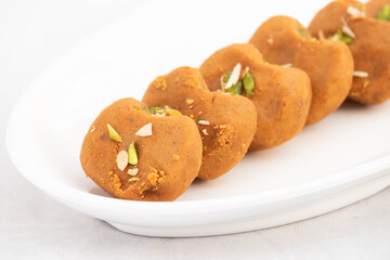 Indian Subcontinental Mithai Brown Mathura Peda Or Meetha Pera Made Of Condensed Milk Fudge Khoya Mawa Kesar Khoa Pista Mava Malai In Pure Desi Ghee Arranged In Tray. White Background With Copy Space