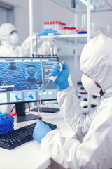 Scientist taking blood sample from test tube using micropipette. Doctor working with various...